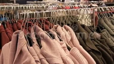 服装店购物中心衣架上挂着大量不同颜色的新款<strong>保暖</strong>时尚毛衣